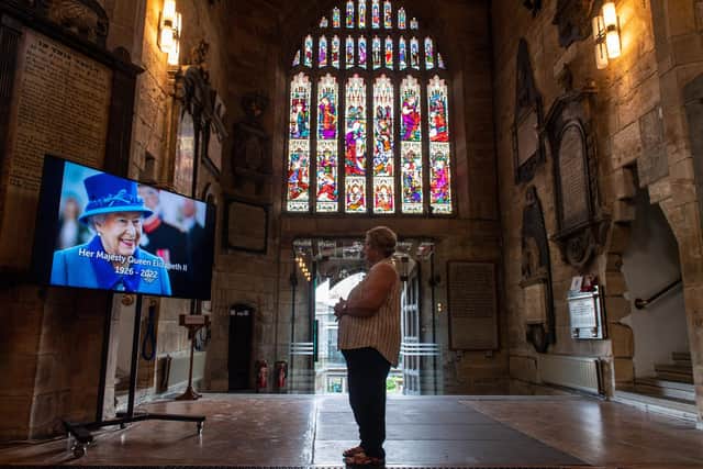 A screen displays a portrait of HRH Queen Elizabeth at Bradford Cathedral paying respect following her death. PIC: Bruce Rollinson