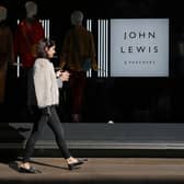 A shopper walks past a John Lewis department store on Oxford Street in London (Photo by Daniel LEAL / AFP)