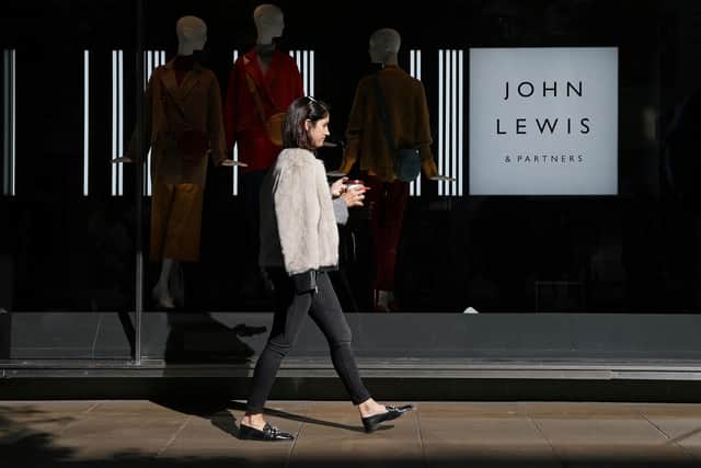 A shopper walks past a John Lewis department store on Oxford Street in London (Photo by Daniel LEAL / AFP)