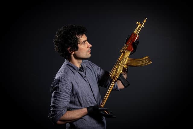 Jamie Hood, Conservation and Technical Manager with the golden Iraqi 'Tabuk' AK-47 style assault rifle, associated with the Hussein family photographed for The Yorkshire Post by Tony Johnson.