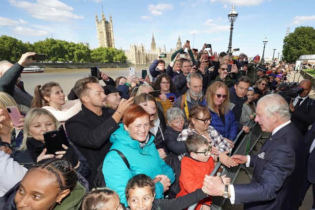 King Charles III meets members of the public in the queue along the South Bank, near to Lambeth Bridge, as they wait to view Queen Elizabeth II lying in state ahead of her funeral on Monday (Photo by Aaron Chown-WPA Pool/Getty Images)