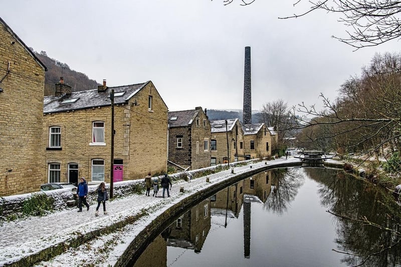 Walkers on the towpath beside the Rochdale Canal in Hebden Bridge as snow hit the region.