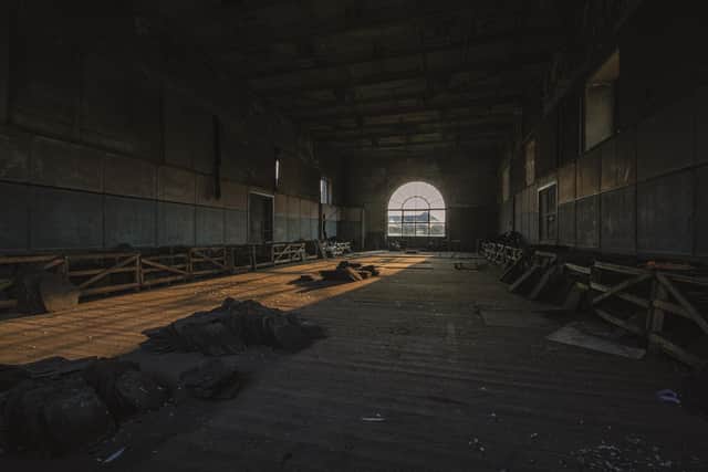 Light falls on the floor through the arched window of an abandoned Yorkshire mill.
 From the book Abandoned Britain by Simon Sugden.