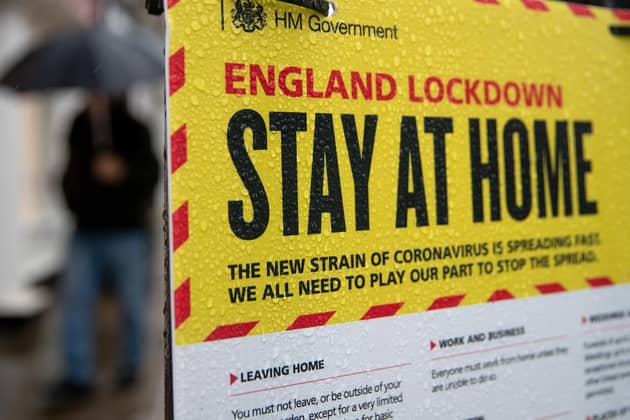 People walking past a Government sign warning people to stay at home during the pandemic in 2021. PIC: Andrew Matthews/PA Wire