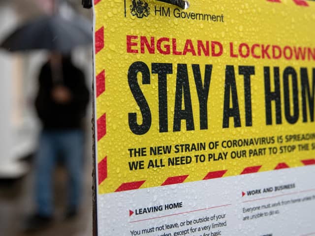People walking past a Government sign warning people to stay at home during the pandemic in 2021. PIC: Andrew Matthews/PA Wire
