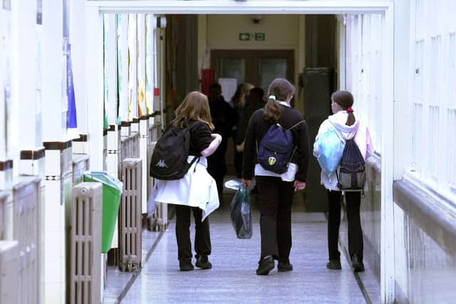 Pupils walk along a school corridor.