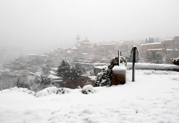 This picture shows the mountain village of Valldemossa covered in snow, on the Spanish Balearic island of Mallorca (Photo by JAIME REINA/AFP via Getty Images)