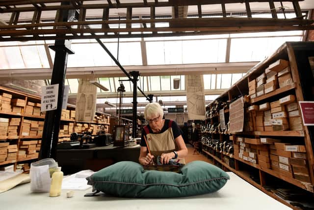 Volunteer Wendy Adams is pictured cleaning one of the books with a fine brush for Heritage Day at Sunny Bank Mills, Farsley, the making of Woodhouse's fine worsted cloth and in the running of Sunny Bank Mills.. Picture by Simon Hulme