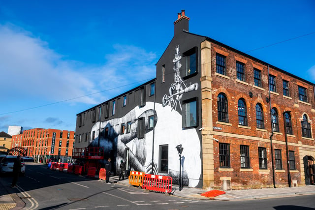Artist known as Phlegm a Welsh-born Sheffield-based muralist and artist working on a massive mural on the side of the former Eye Witness Works at the junction of Hilton Street, and Headford Street in Sheffield.