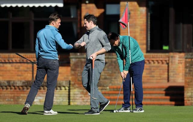 Golfers touch elbows instead of shaking hands as they play at Pine Ridge Golf Club on March 22 2020 in Camberley, England (Photo: Warren Little/Getty Images)