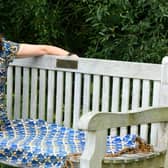 Author Daxa Patel sat on her father's memorial bench in Golden Acre park in Leeds.