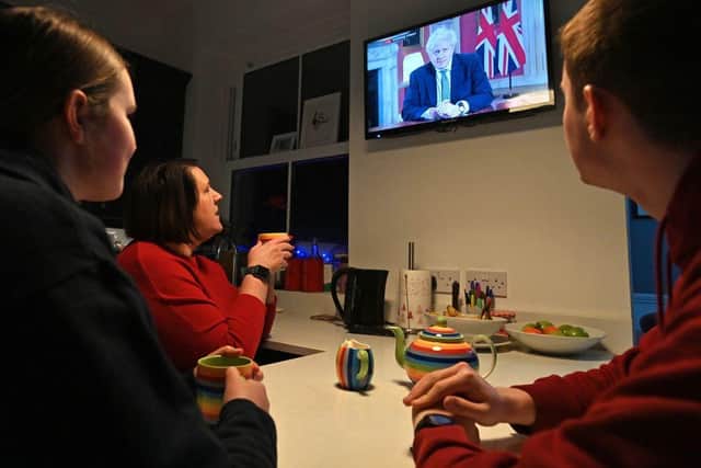 A family gather around the television in Liverpool to watch Britain's Prime Minister Boris Johnson give a televised message to the nation from 10 Downing Street on 4 January (Photo: PAUL ELLIS/AFP via Getty Images)