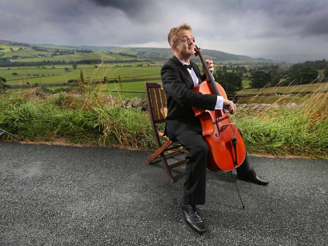Ben Crick, conductor of the re-formed Yorkshire Symphony Orchestra (YSO), plays his cello in the Aire valley near Skipton. (credit: Lorne Campbell / Guzelian)