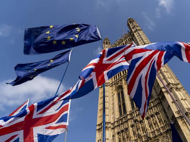 Union Jack and EU fags flutter outside the Houses of Parliament in Westminster. PIC: NIKLAS HALLE'N/AFP/Getty Images