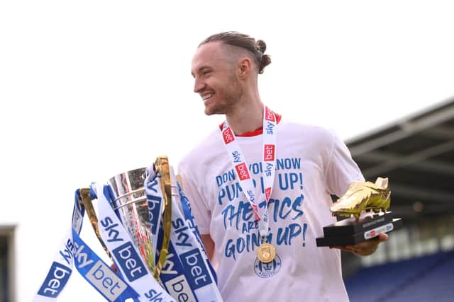 SHREWSBURY, ENGLAND - APRIL 30: Will Keane of Wigan Athletic celebrates with the League One trophy and Golden Boot award after their sides victory and promotion to the Championship during the Sky Bet League One match between Shrewsbury Town and Wigan Athletic at Montgomery Waters Meadow on April 30, 2022 in Shrewsbury, England. (Photo by Charlotte Tattersall/Getty Images)