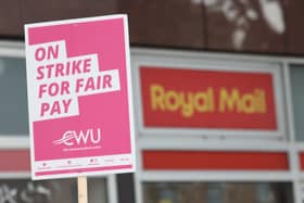 A sign held by a postal worker from the Communication Workers Union (CWU) on a picket line at a Royal Mail delivery office. PIC: PA