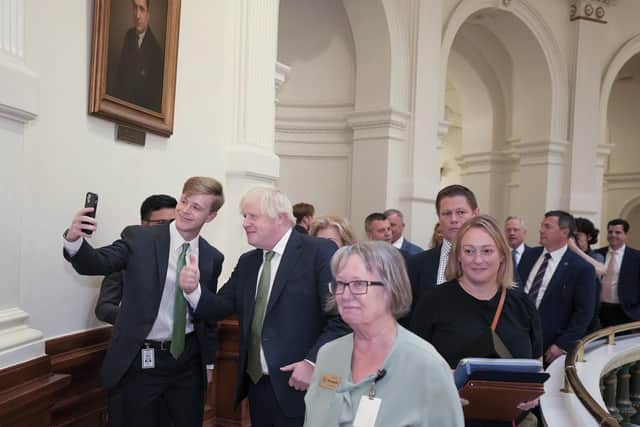Former British Prime Minister Boris Johnson poses for photos after an economic development meeting with Texas Gov. Greg Abbott at the Capitol in Austin, Texas, on Tuesday May 23, 2023. After the meeting Johnson toured the Legislative Reference Library and visited the Senate Chamber. (Jay Janner/Austin American-Statesman via AP)