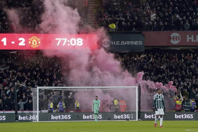 FLARE PLAY: Manchester United's fans celebrate their Bramall Lane winner, scored by Diogo Dalot