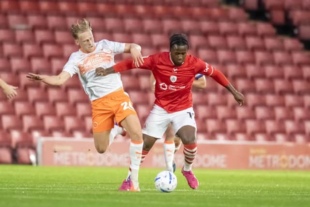 Barnsley's Reyes Cleary takes on Blackpool's Finley Munroe. Photo: Tony Johnson.