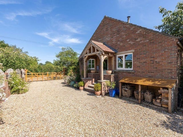 The property is approached through timber double gates onto a gravelled driveway.