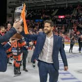 THE GRIND: Sheffield Steelers head coach Aaron Fox (right) hands the Challenge Cup trophy to assistant coach Carter Beston-Will after beating Guildford Flames 3-1 last month. They have since added the Elite League regular season championship, setting up a potential treble. Picture: Tony Johnson.