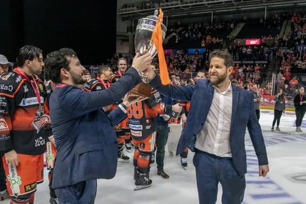 THE GRIND: Sheffield Steelers head coach Aaron Fox (right) hands the Challenge Cup trophy to assistant coach Carter Beston-Will after beating Guildford Flames 3-1 last month. They have since added the Elite League regular season championship, setting up a potential treble. Picture: Tony Johnson.