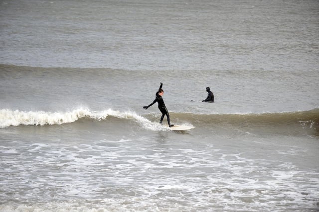 A surfer tries to keep upright as Storm Dudley hits Sunderland.