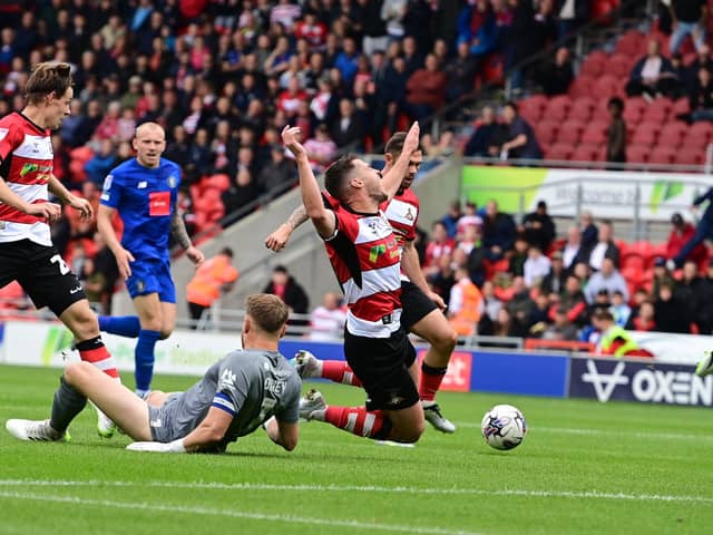 Picture Howard Roe/AHPIX LTD, Football, Sky Bet League Two,
Doncaster Rovers v Harrogate Town ,
Eco Power Stadium, Doncaster, UK,03/8/2023, K.O 3.00pm
Doncaster Rovers' Tommy Rowe is brought down by  Mark Oxley 
