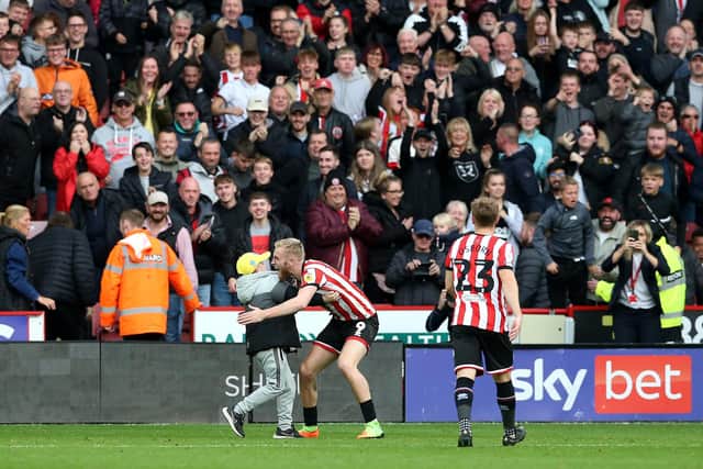 Sheffield United's Oli McBurnie embraces a young pitch invader during the Sky Bet Championship match at Bramall Lane, Sheffield. Picture: Barrington Coombs/PA Wire.