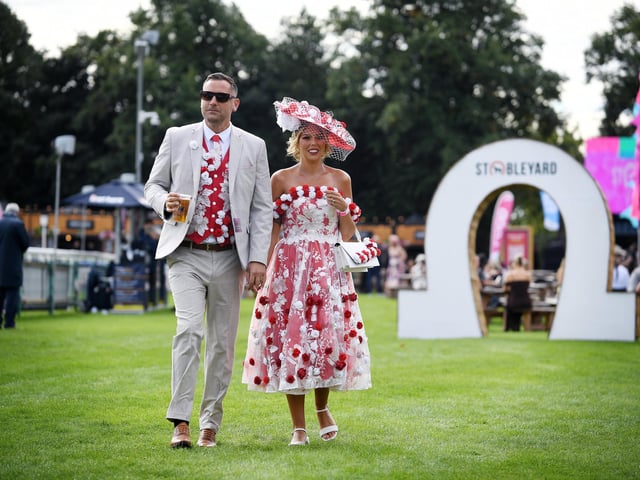 A couple strolling at Ladies Day at Doncaster Racecourse