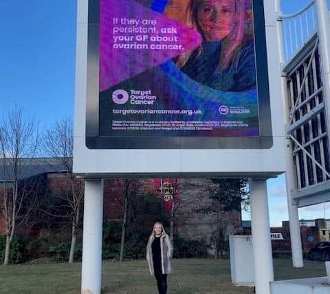 Natalie Wild outside Target Ovarian Cancer awareness billboard by Meadowhall shopping centre.