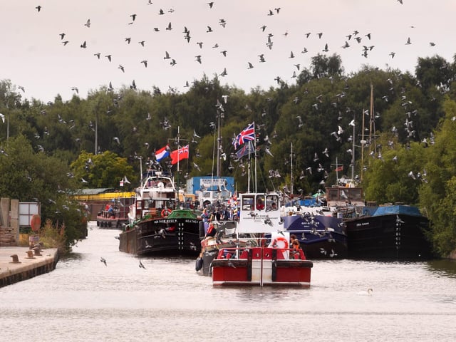 A flock of birds takes flight above the flotilla as the vessels continue their journey through Goole's historic waterways