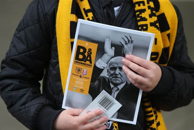 A Hull City fan clutches a match-day programme (Photo: PA)