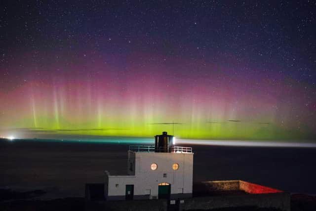 The Northern Lights or Aurora Borealis, in the sky over Bamburgh lighthouse at Stag Rock in Northumberland. (Owen Humphreys / PA Wire)