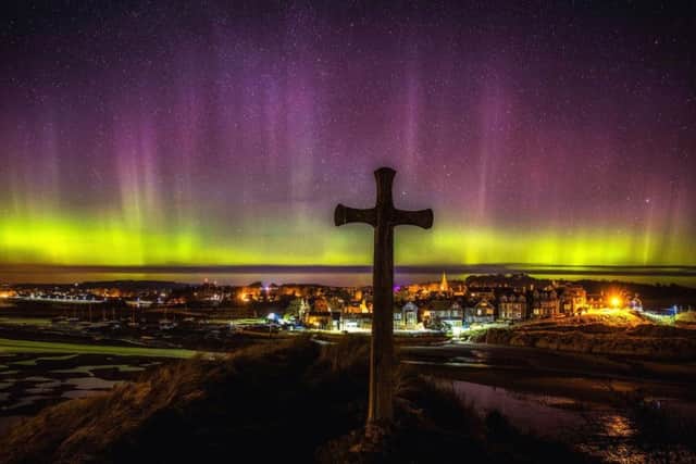 The Northern Lights over Alnmouth in Northumberland at the St Cuthbert's Cross, which is said to be the location where St Cuthbert agreed to become Bishop of Lindisfarne when petitioned by the King. (Owen Humphreys / PA Wire)