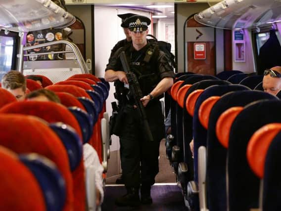 Armed British Transport Police Specialist Operations officers on board a Virgin train to Birmingham New Street at Euston station in London as armed police officers are patrolling on board trains nationwide for the first time. PA