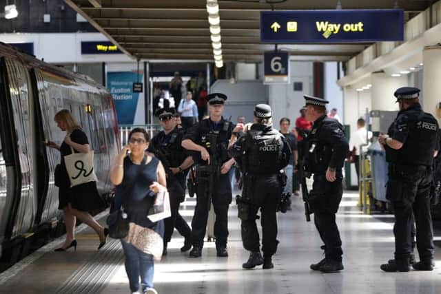 Armed British Transport Police Specialist Operations officers on the platform before boarding a Virgin train to Birmingham New Street at Euston station in London as armed police officers are patrolling on board trains nationwide for the first time. PA