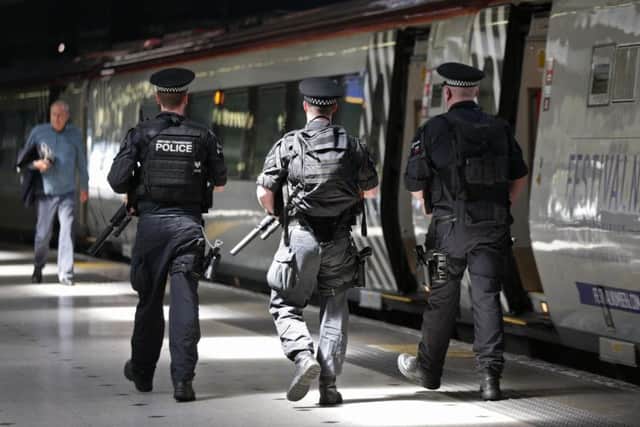 Armed British Transport Police Specialist Operations officers on the platform before boarding a Virgin train to Birmingham New Street at Euston station in London as armed police officers are patrolling on board trains nationwide for the first time. PA
