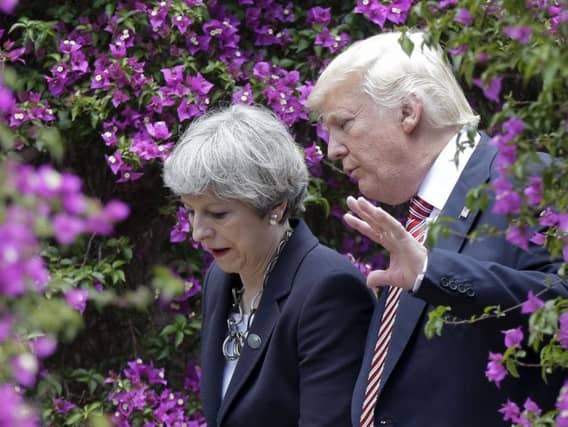 USA President Donald Trump talks with British Prime Minister Theresa May in Italy, on Friday. (AP Photo/Luca Bruno)