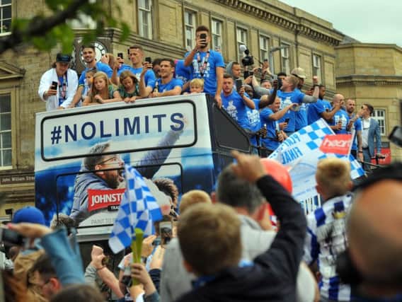 Fans salute Huddersfield Town's players during the open top bus tour
