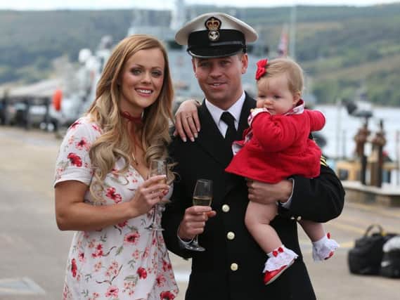 Petty Officer (Mine Warfare) Mark Titman with Laura Campbell and their eight month old daughter Ava after proposing to her as Crew 1, who have spent the last seven and a half months operating the HMS Penzance, returns to HM Naval Base Clyde after three years on deployment in the Gulf. PA