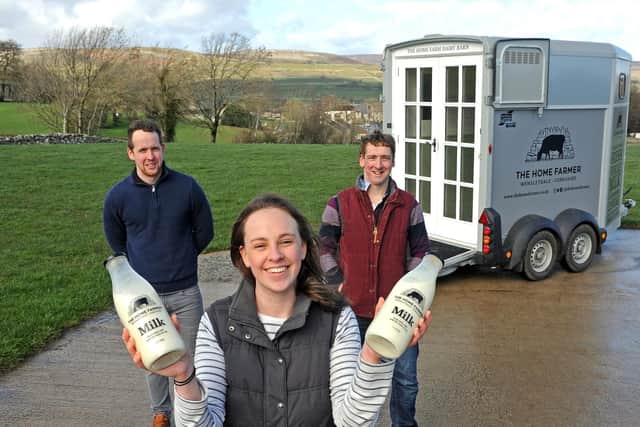 Aysgarth dairy farmers Ben, right, and Samantha Spence and Ben's brother Adam Spence, left, have converted a horse box into a mobile shop containing a vending machine, from which customers can pour fresh whole milk into glass bottles.