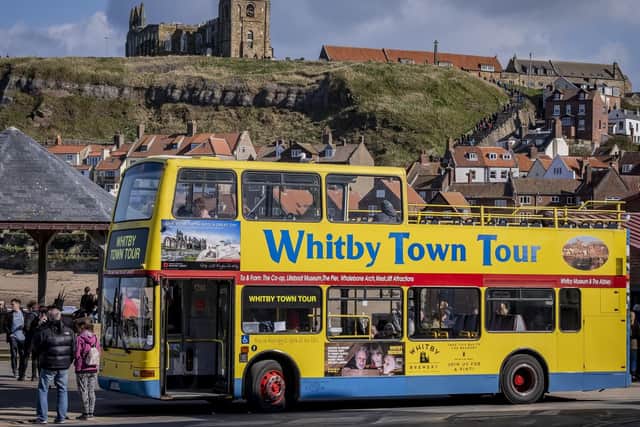 Visitors enjoy an open-top bus tour of Whitby