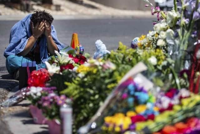 Felipe Avila puts his head in his hands as he cries Sunday, Aug. 4, 2019, in El Paso, Texas, at the place where locals came to honor the memory of the victims of the mass shooting occurred in Walmart on Saturday, Aug. 3, 2019. (Lola Gomez/Austin American-Statesman via AP)