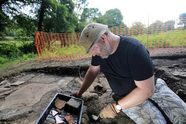 Adrian Mann examines some of the artefacts they have uncovered. Picture: Chris Etchells