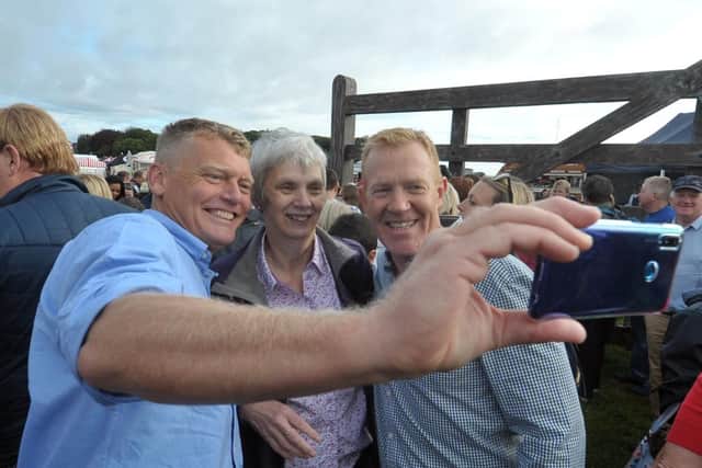 Countryfile presenters Tom Heap (left) and Adam Henson pose for pictures with a visitor at Countryfile Live during its first northern run at Castle Howard near York. Picture by Tony Johnson.