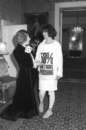Prime Minister Margaret Thatcher greets fashion designer Katharine Hamnett, wearing a t-shirt with a nuclear missile protest message, at 10 Downing Street, where she hosted a reception for British Fashion Week designers.