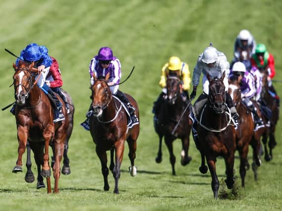 William Buick riding Masar (L, blue) wins The Investec Derby during Investec Derby Day at Epsom Downs Racecourse. Photo: Alan Crowhurst/Getty Images