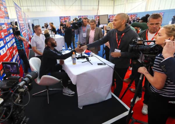England's Raheem Sterling (left) shakes hands with Stan Collymore during the media day at St George's Park, Burton.