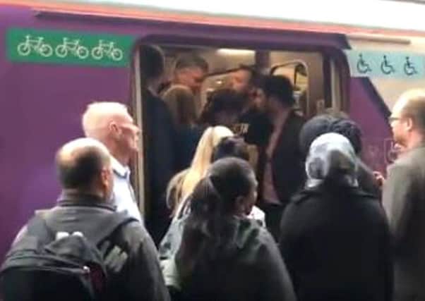 Commuters trying to board a packed Northern Rail train